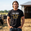 Man wearing RMRL Core Identity Tee in black with Real Men Real Life Bible and cross logo on farm background