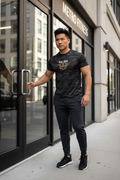 Asian man at gym entrance wearing RMRL Black Camo Dry-Fit Tee with Real Men Real Life center-chest logo